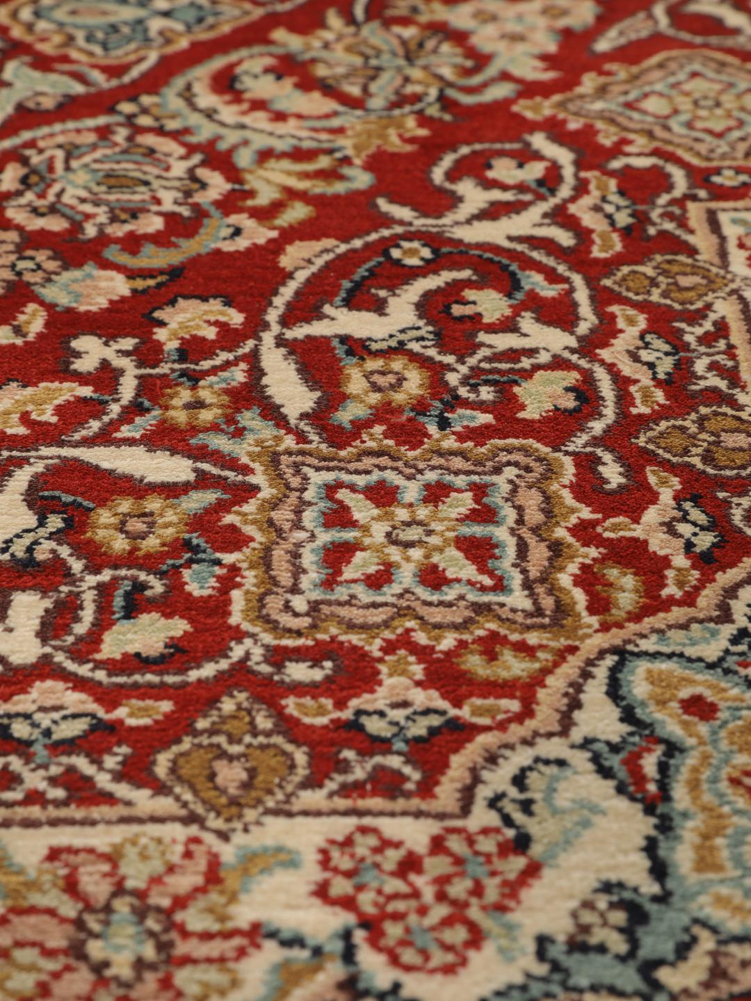 Hand-knotted Kashmir silk rug from India with a vibrant red field and intricate floral motifs.