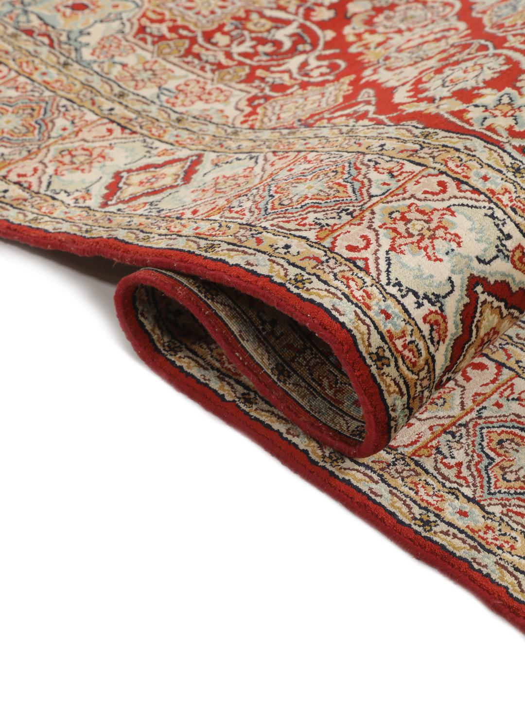 Hand-knotted Kashmir silk rug from India with a vibrant red field and intricate floral motifs.