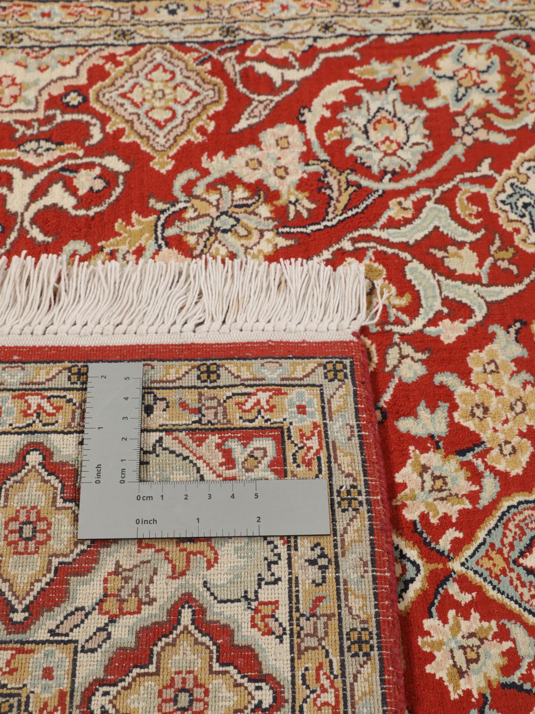 Hand-knotted Kashmir silk rug from India with a vibrant red field and intricate floral motifs.