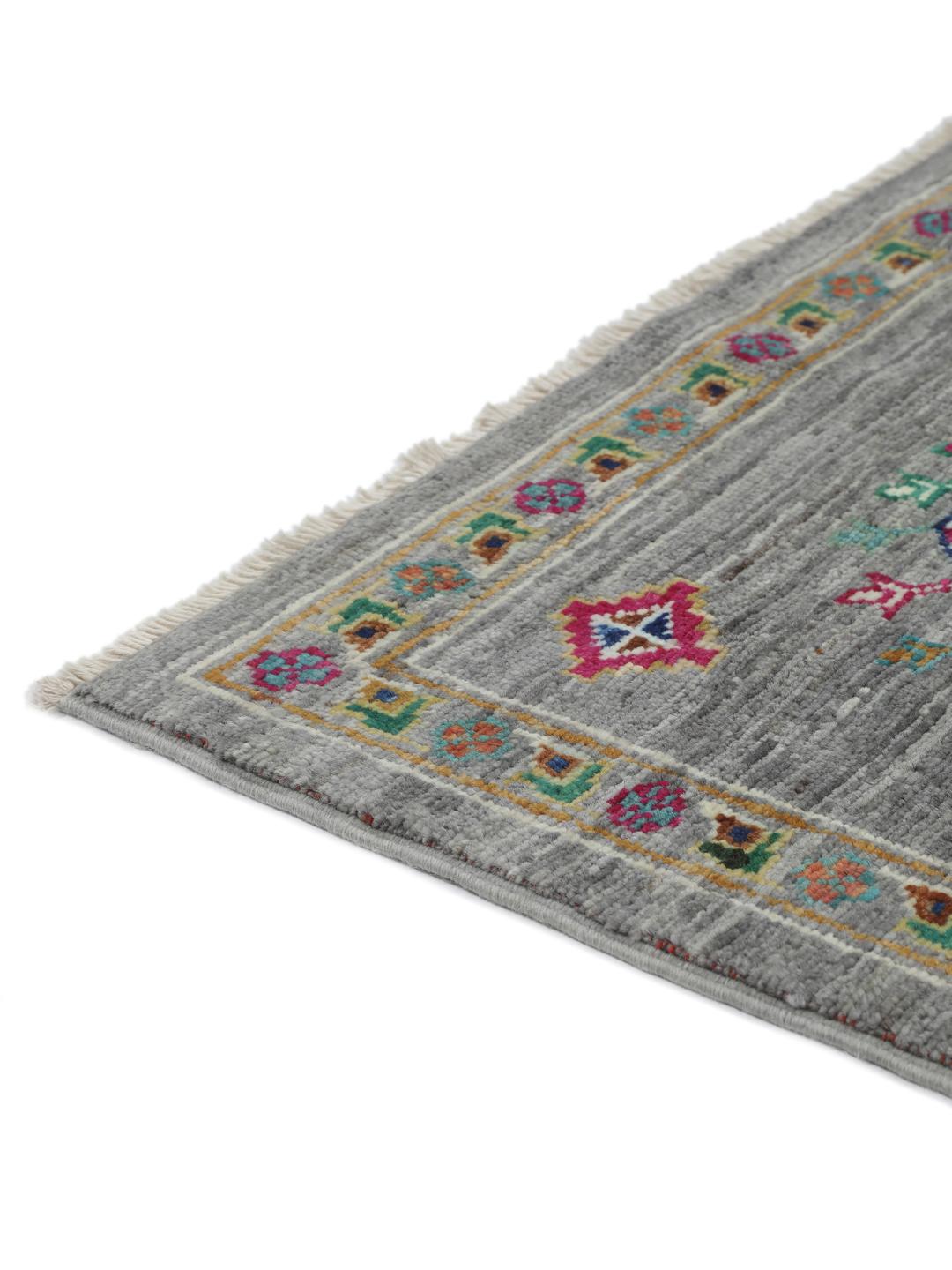Hand-knotted rug from the Middle East with vibrant geometric medallions on a grey background