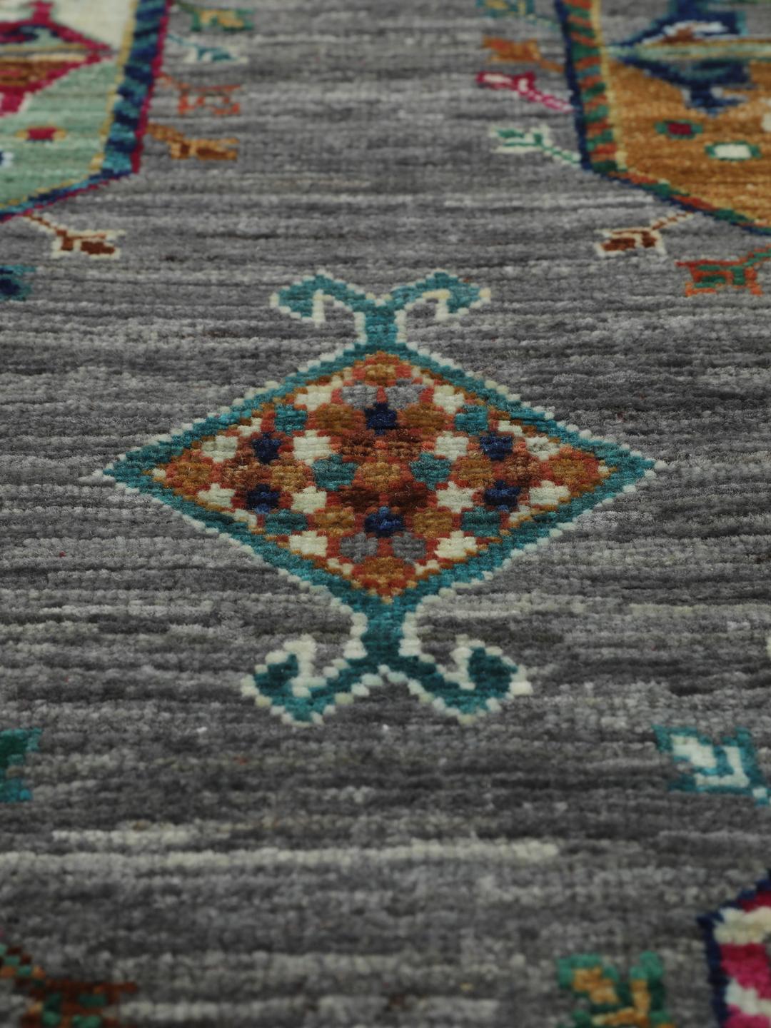 Hand-knotted rug from the Middle East with vibrant geometric medallions on a grey background