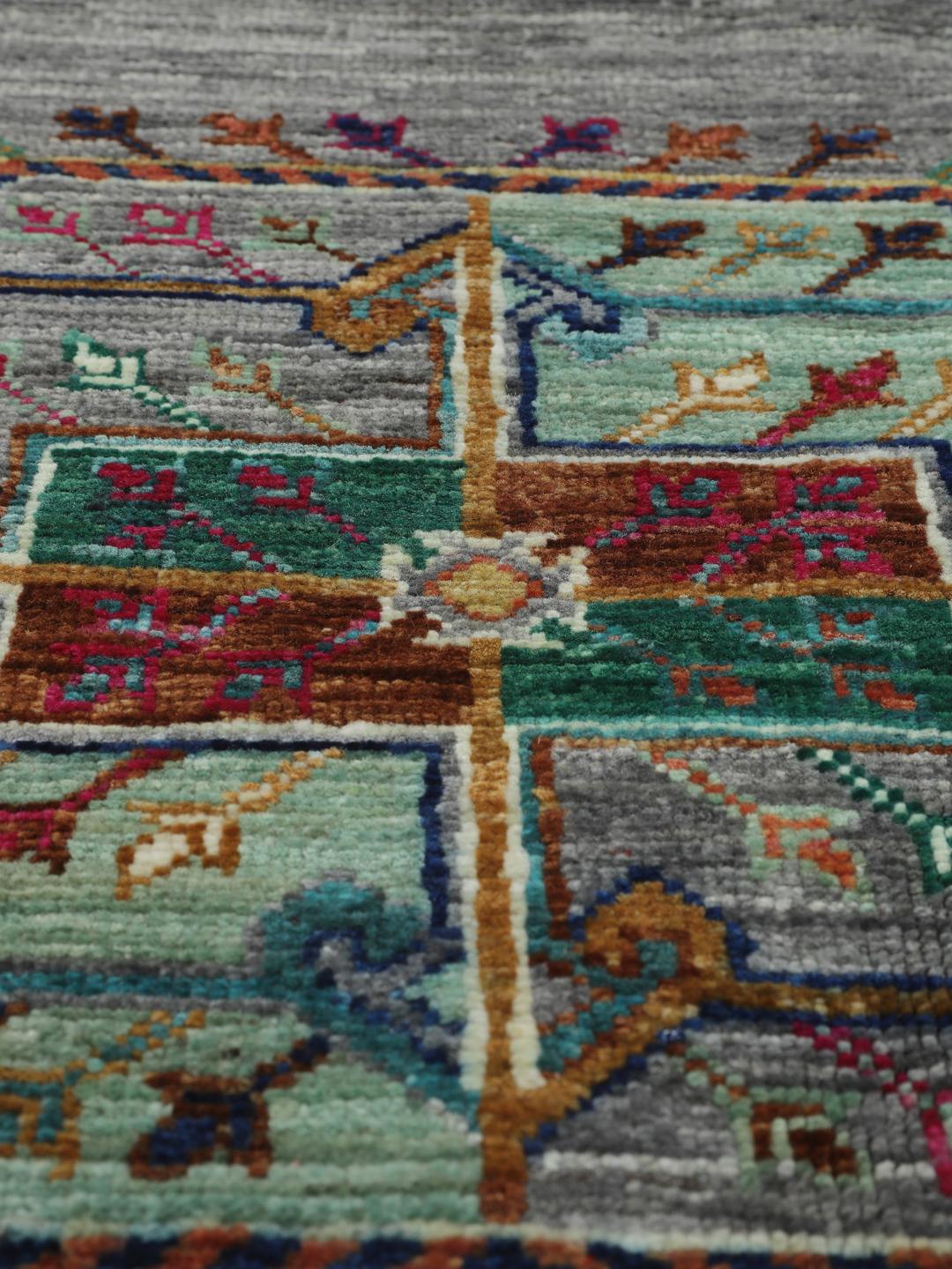 Hand-knotted rug from the Middle East with vibrant geometric medallions on a grey background