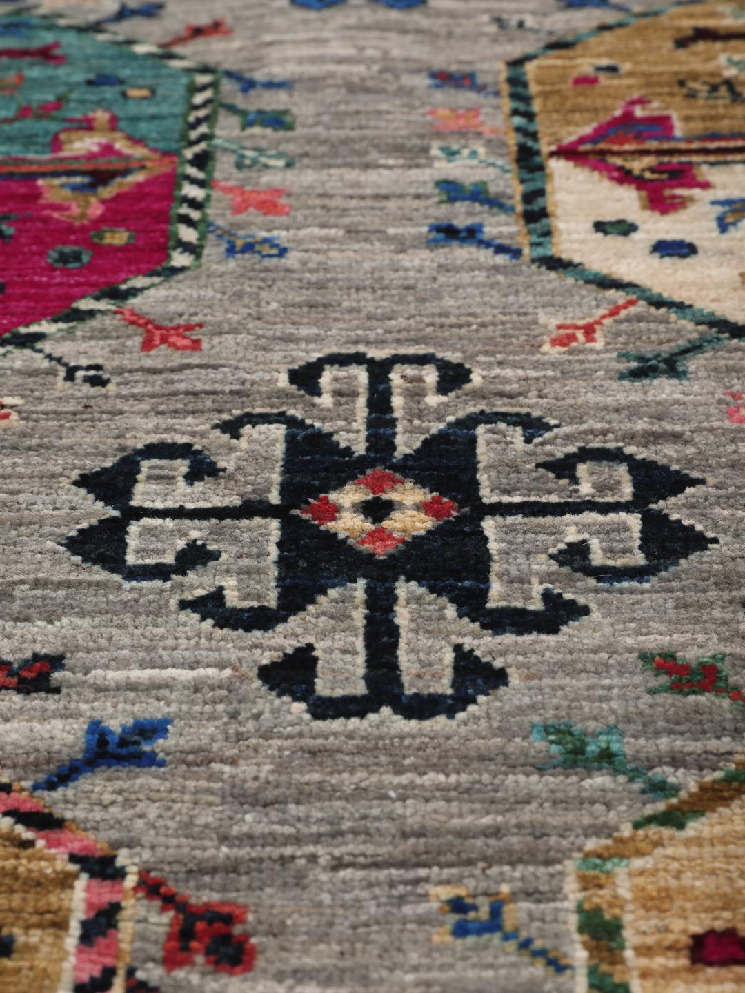 Hand-knotted Afghan rug with vibrant medallion patterns on a grey field