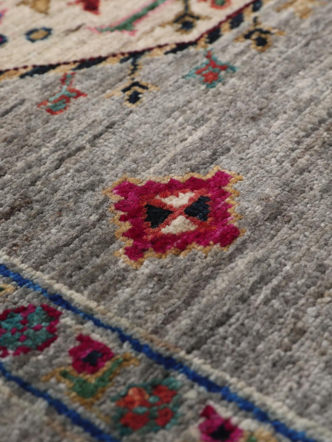 Hand-knotted Afghan rug with vibrant medallion patterns on a grey field