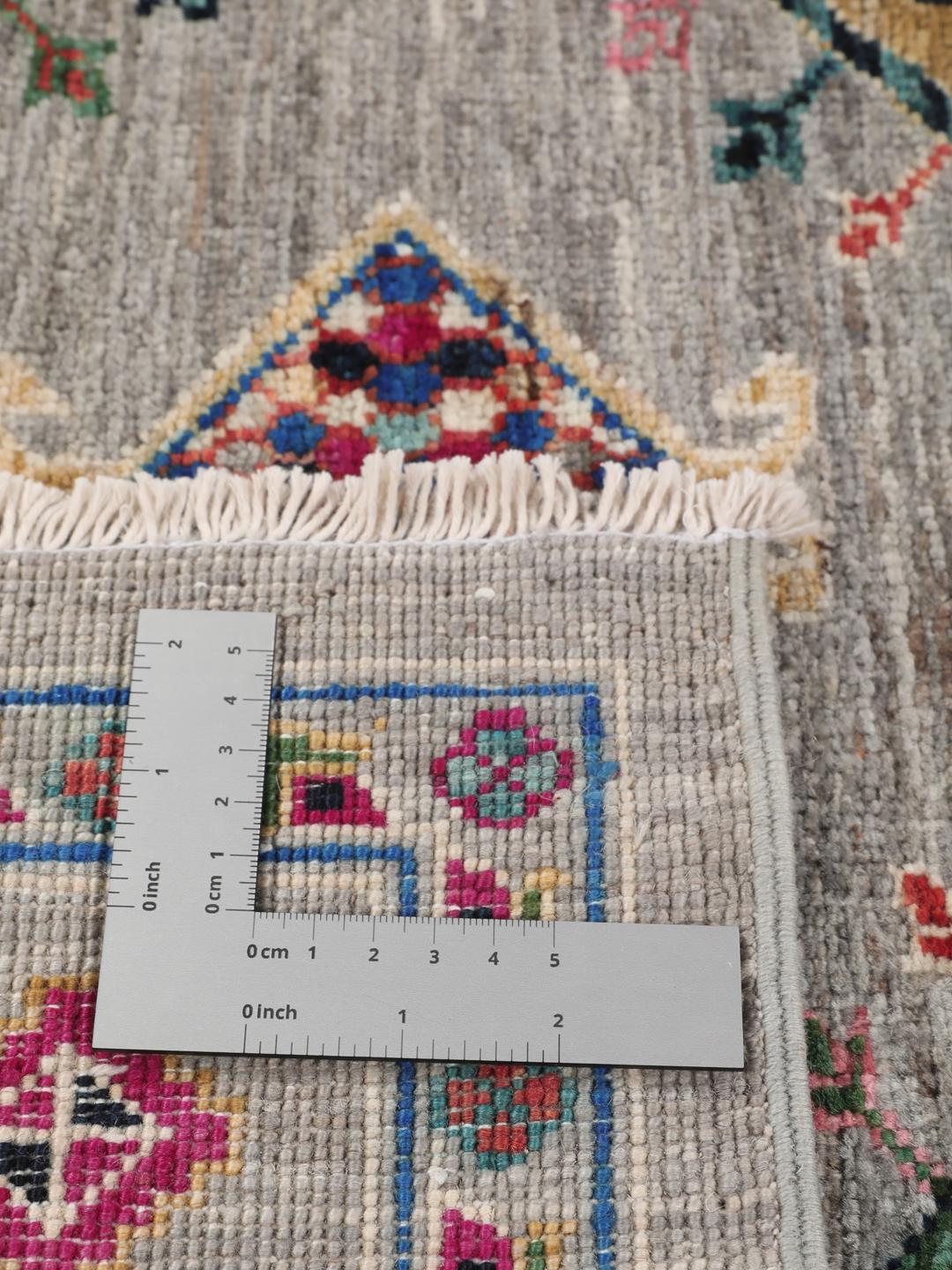 Hand-knotted Afghan rug with vibrant medallion patterns on a grey field