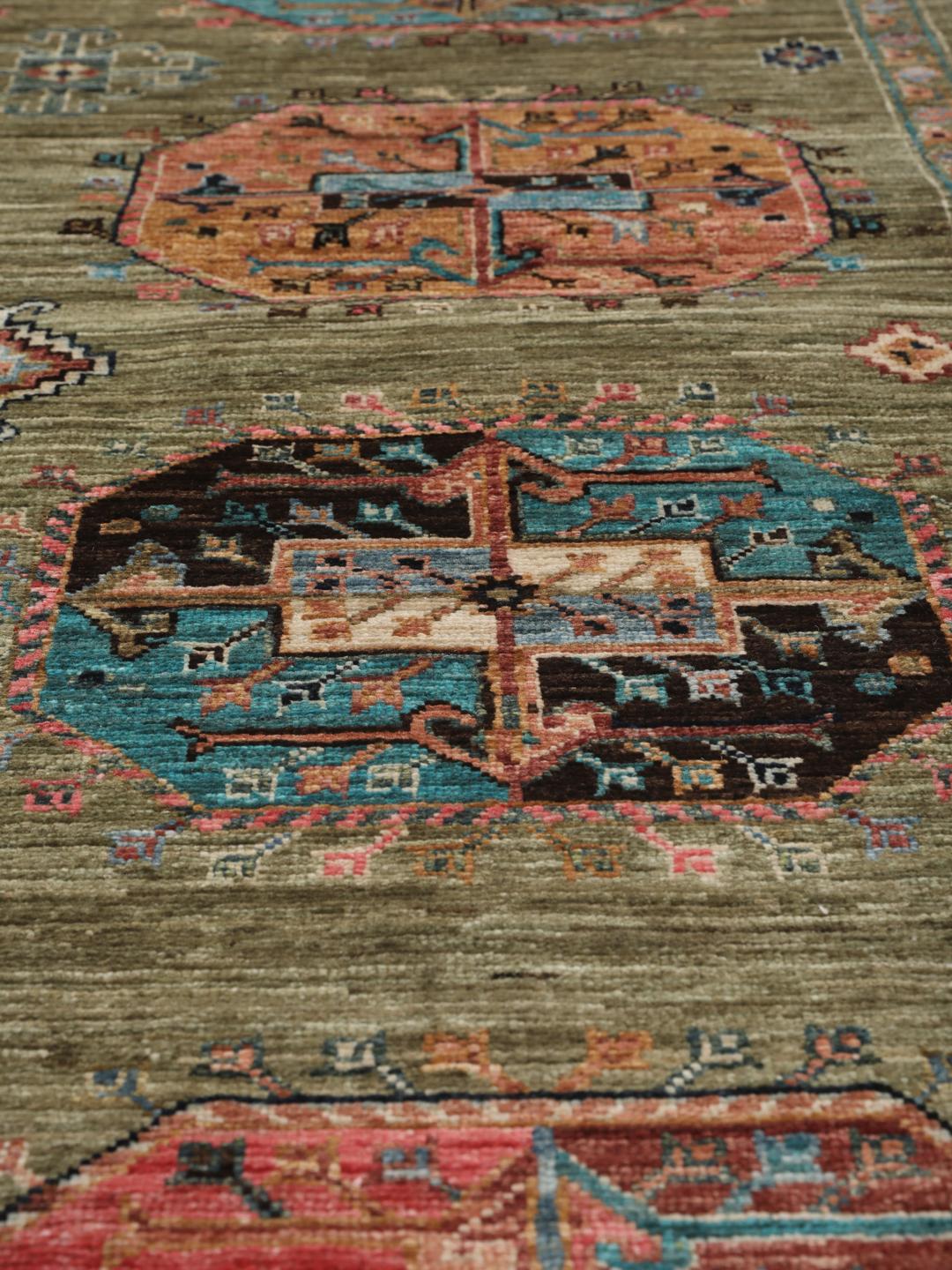 Hand-knotted Afghan rug with olive green field and multi-coloured geometric motifs.