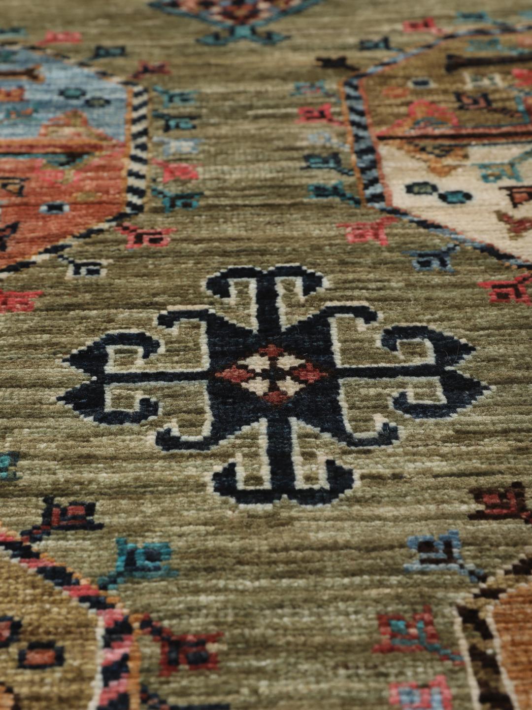 Hand-knotted Afghan rug with olive green field and multi-coloured geometric motifs.