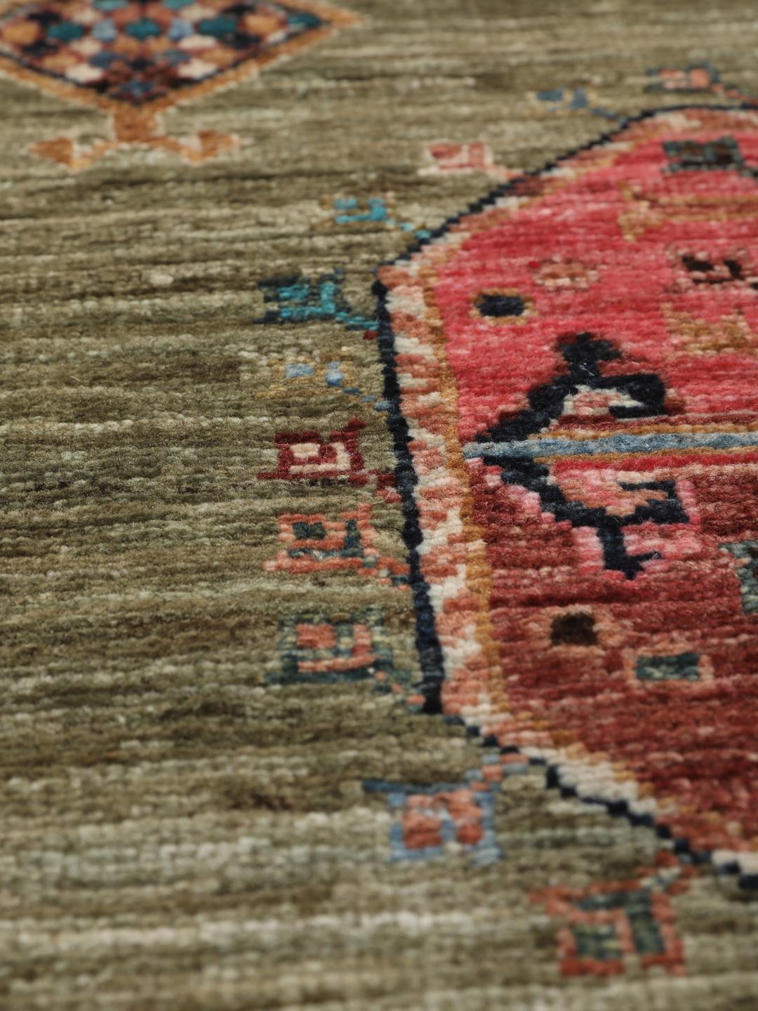 Hand-knotted Afghan rug with olive green field and multi-coloured geometric motifs.
