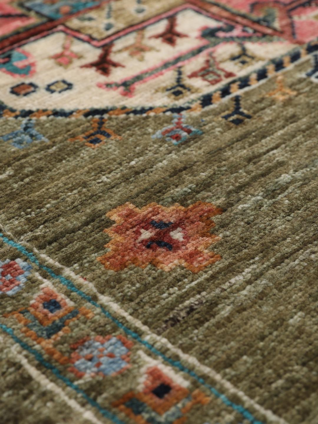 Hand-knotted Afghan rug with olive green field and multi-coloured geometric motifs.