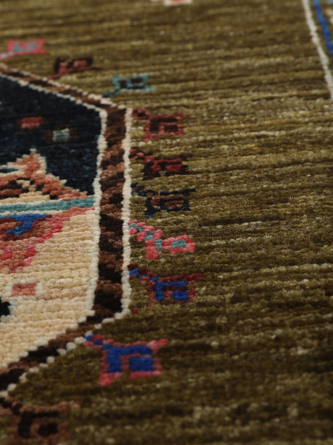 Håndknyttet tæppe fra Afghanistan i grøn med dekorative motiver