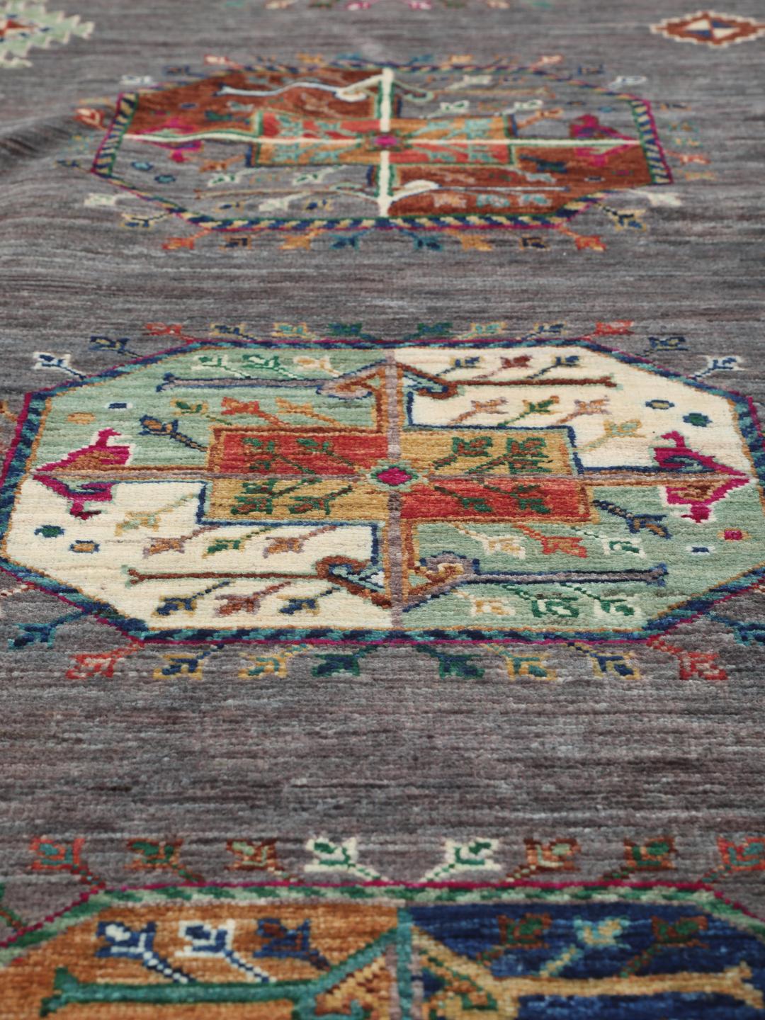 Tapis afghan noué à la main avec des médaillons géométriques vibrants sur un fond gris