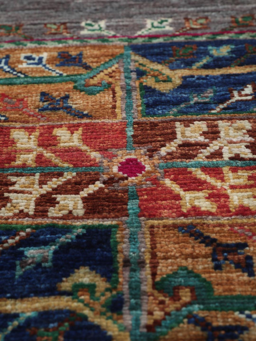 Tapis afghan noué à la main avec des médaillons géométriques vibrants sur un fond gris