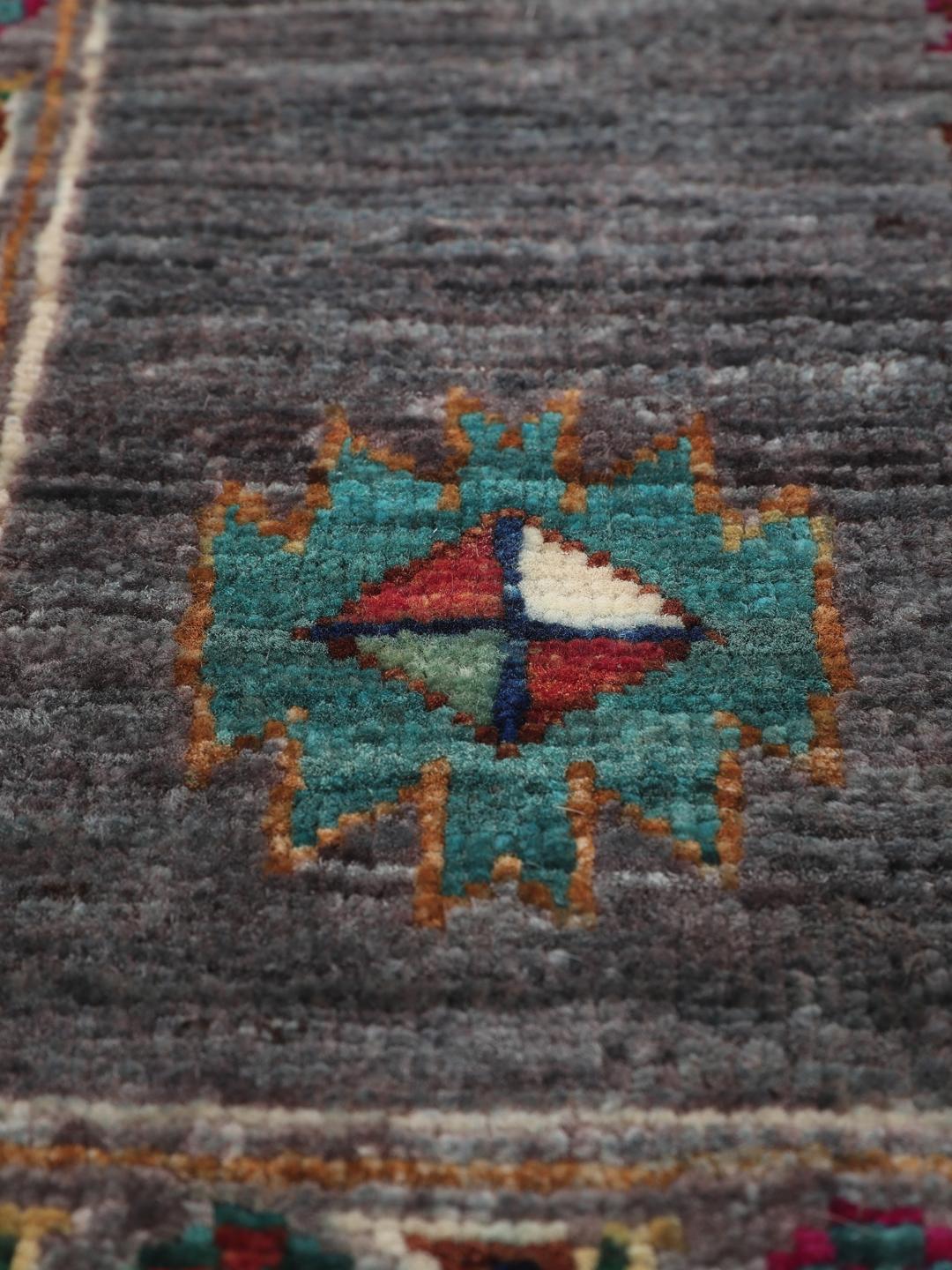 Tapis afghan noué à la main avec des médaillons géométriques vibrants sur un fond gris