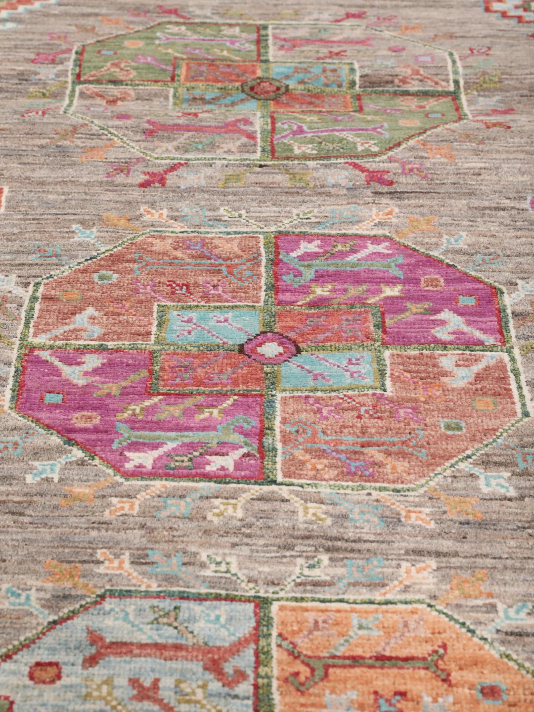 A unique Afghan wool runner featuring colourful geometric motifs on a grey background