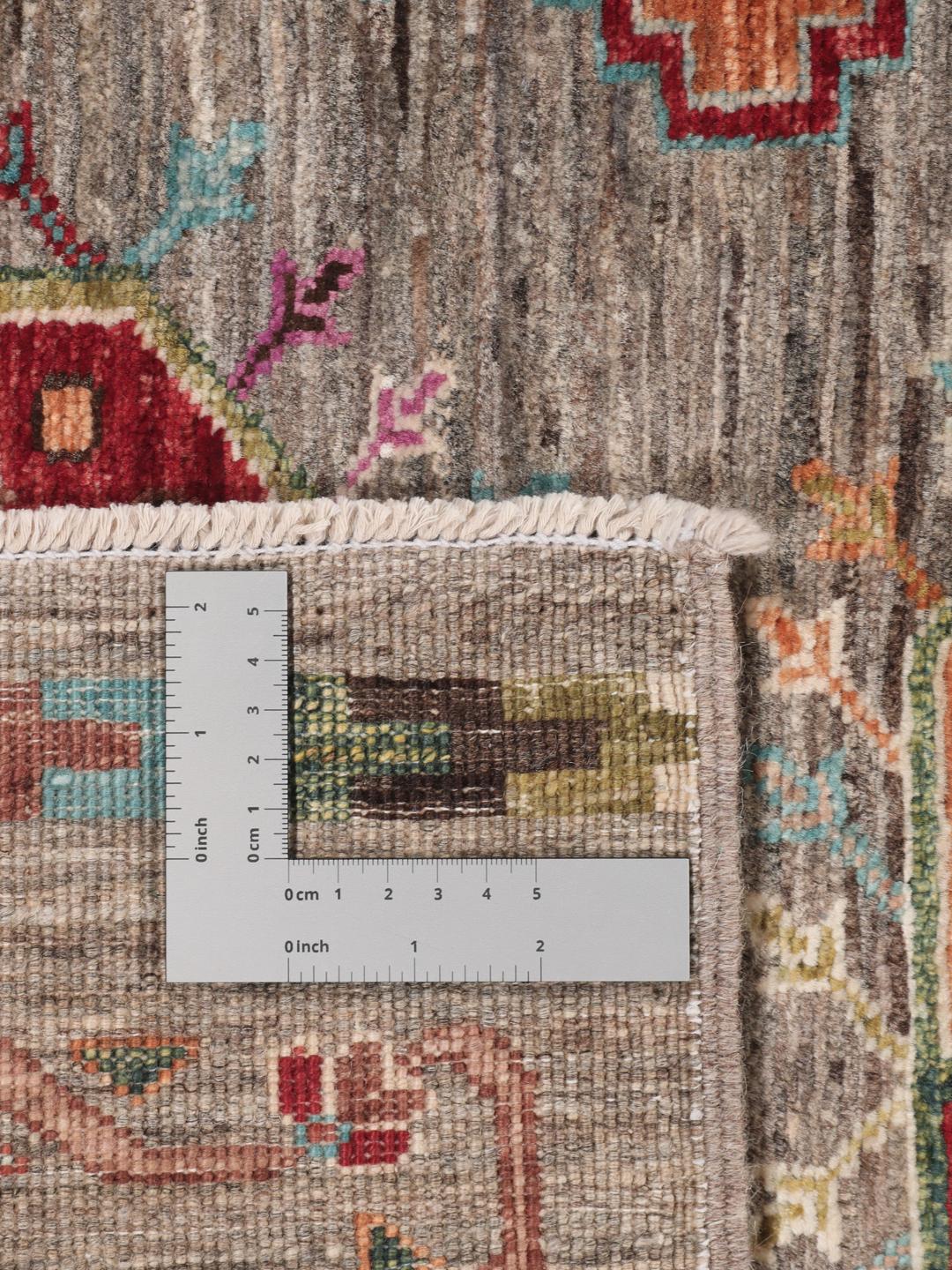 A unique Afghan wool runner featuring colourful geometric motifs on a grey background