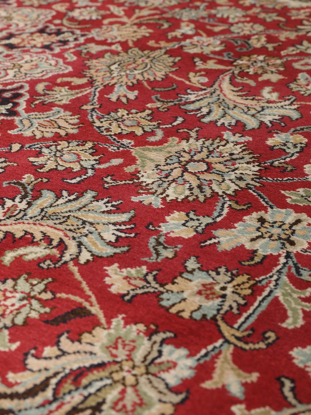 Et håndknyttet Kashmir-silketæppe fra Indien med et indviklet blomstermedallion-mønster i røde og beige nuancer.