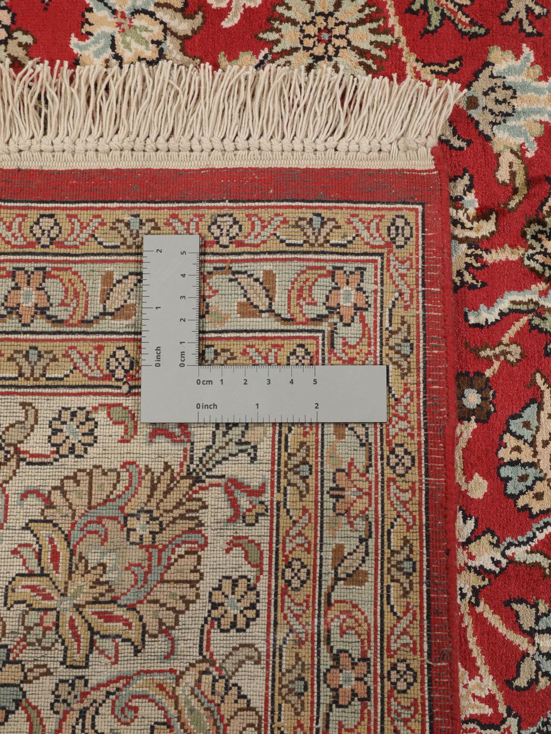Et håndknyttet Kashmir-silketæppe fra Indien med et indviklet blomstermedallion-mønster i røde og beige nuancer.