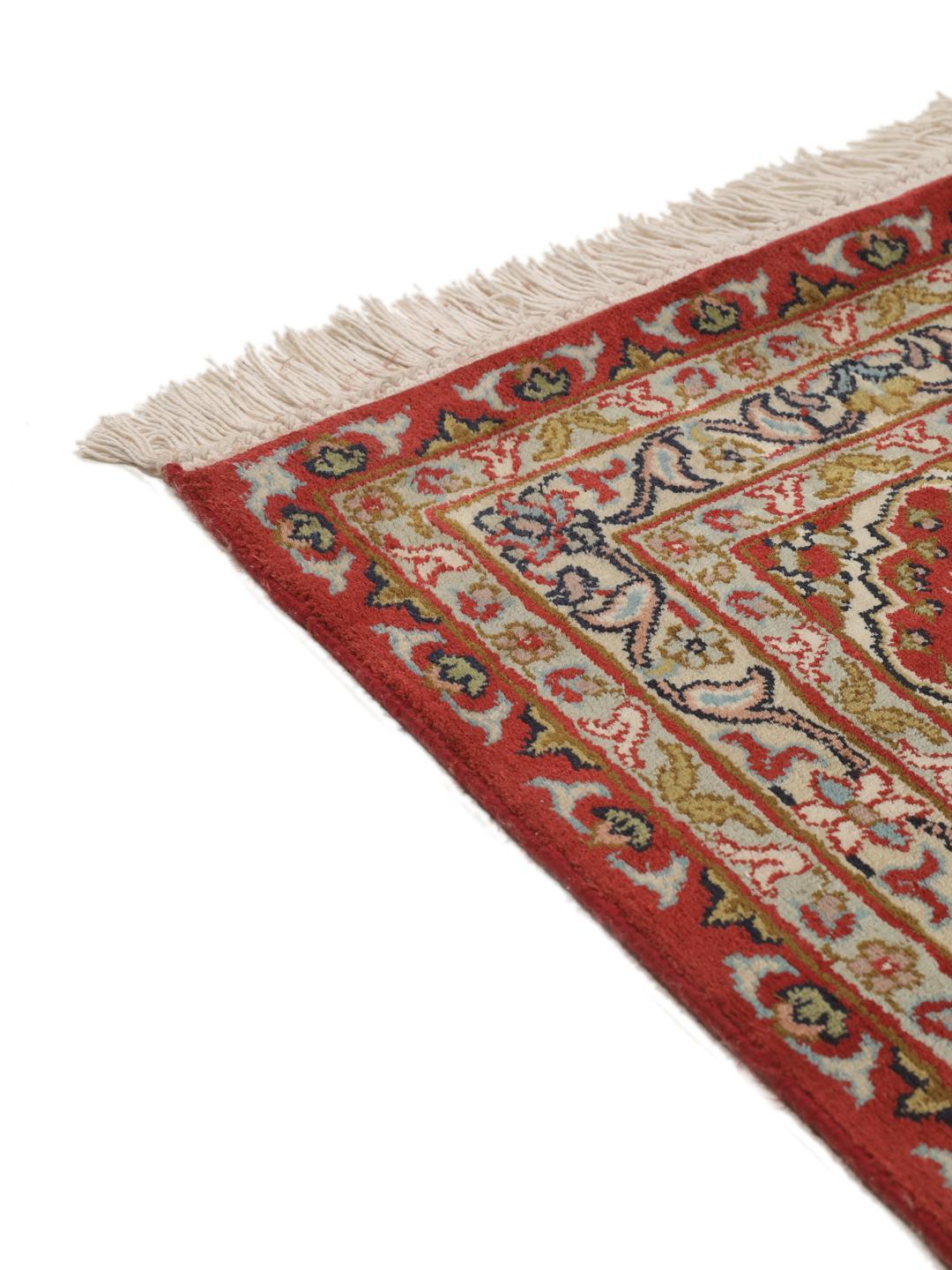 A large rectangular Kashmir silk rug from India with a central medallion on a red field.