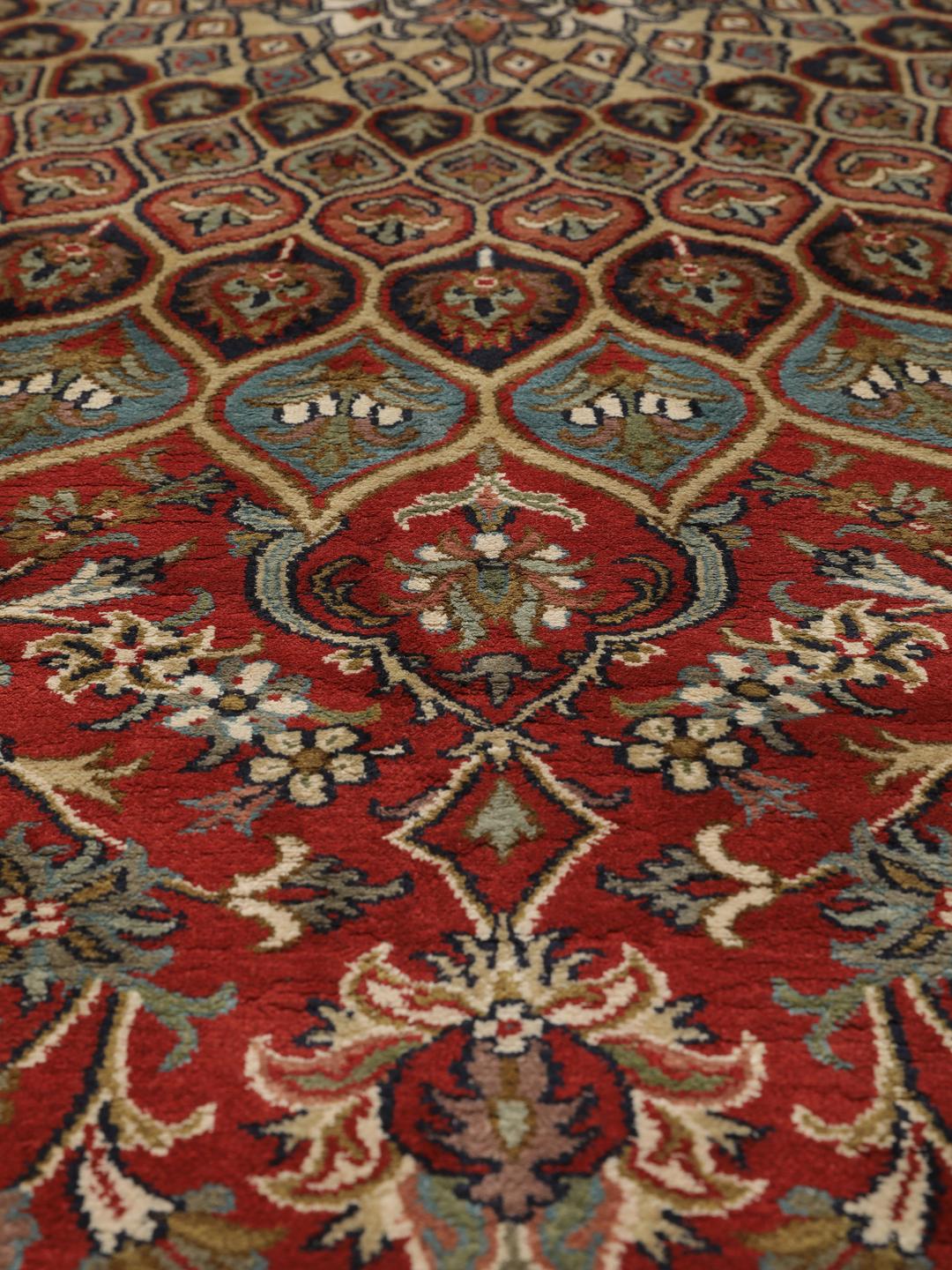 A large rectangular Kashmir silk rug from India with a central medallion on a red field.