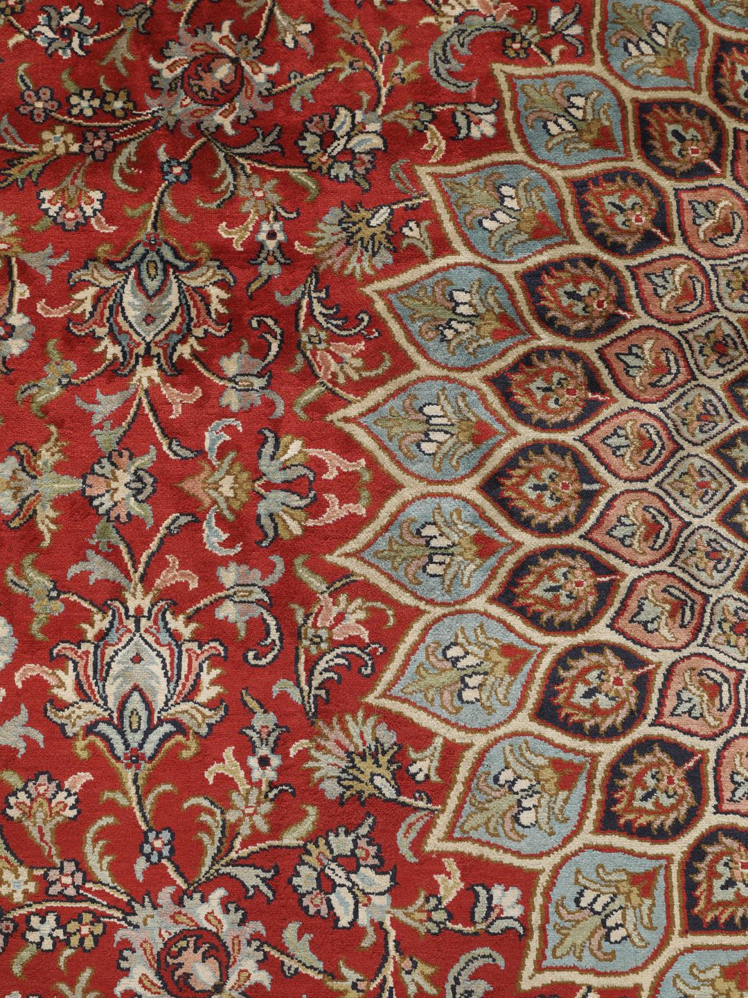 A large rectangular Kashmir silk rug from India with a central medallion on a red field.