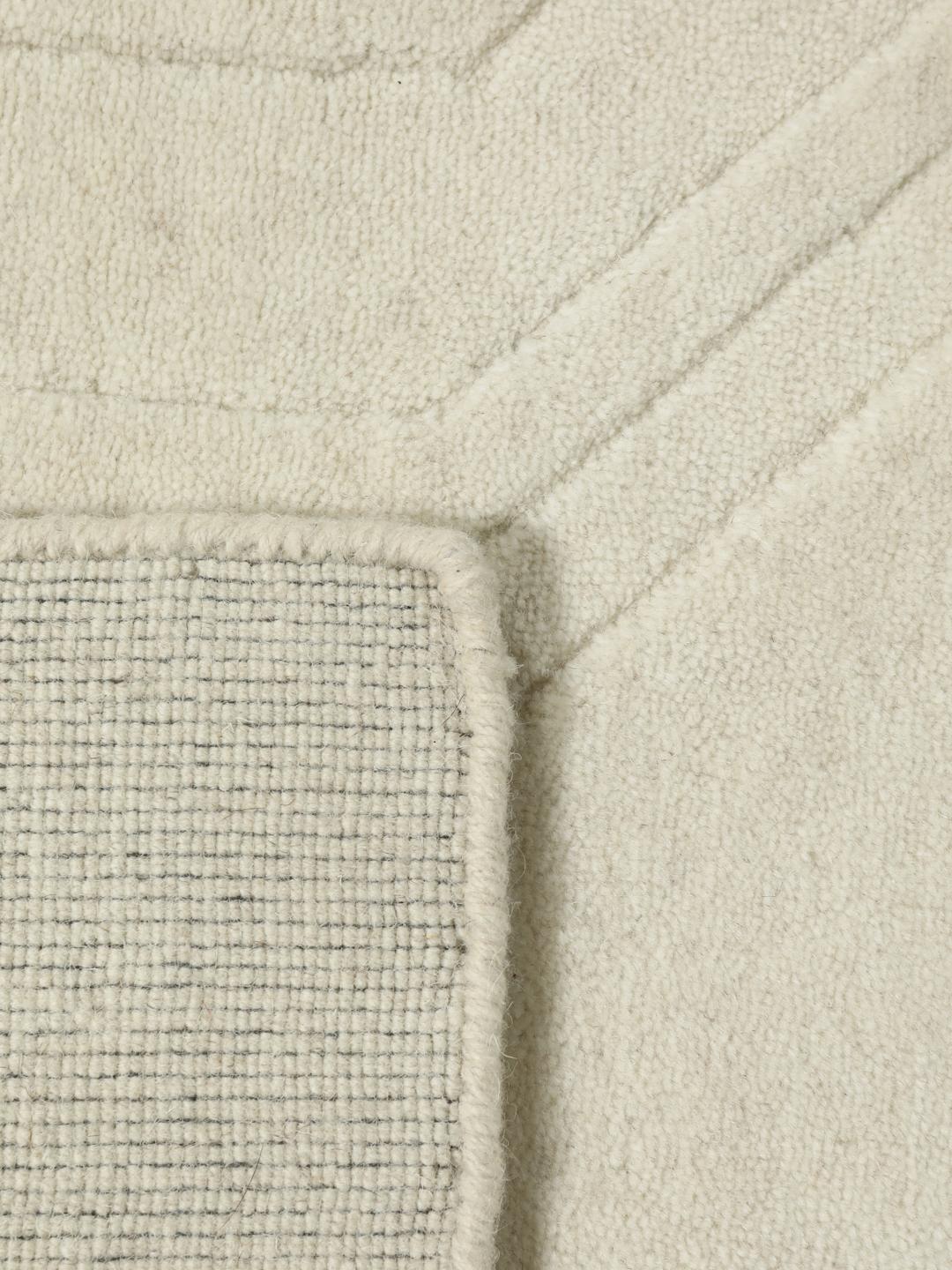 Wit handgeweven wollen tapijt met een subtiel geometrisch patroon