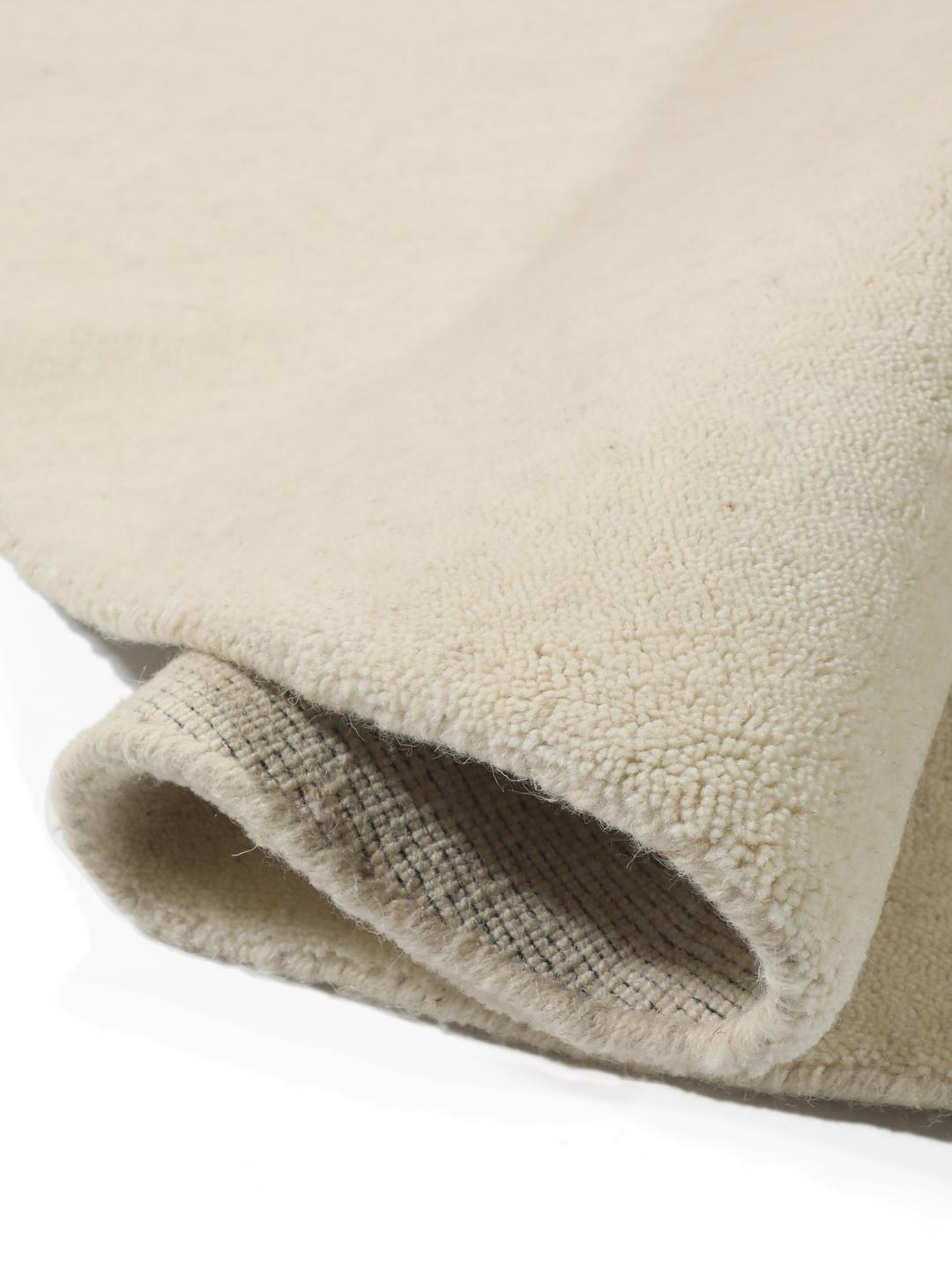 Un tapis rond blanc Handloom fabriqué en laine