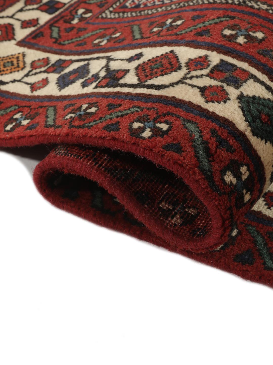 Hand-knotted Afshar wool rug from the Middle East featuring a dark-red and black floral design.