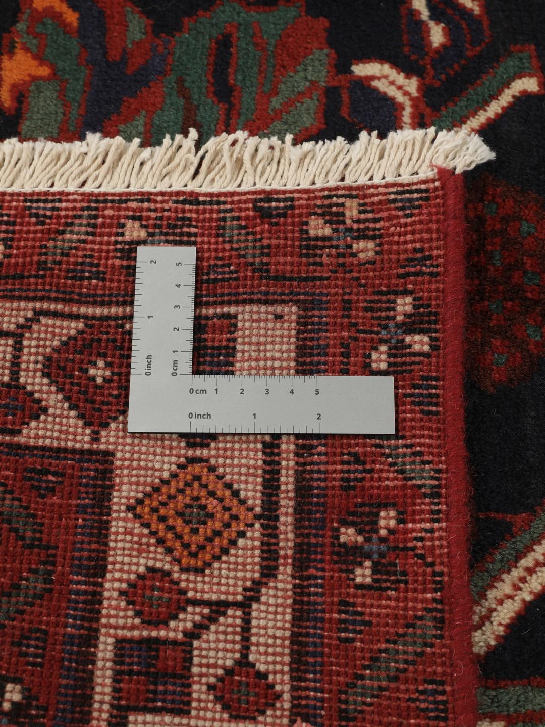 Hand-knotted Afshar wool rug from the Middle East featuring a dark-red and black floral design.