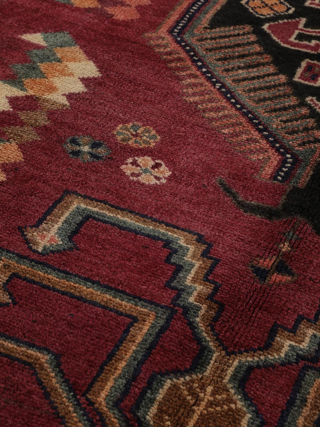 Handgeknoopt Lori-tapijt uit het Midden-Oosten met een donkerrood veld en tribale medaillonpatronen.