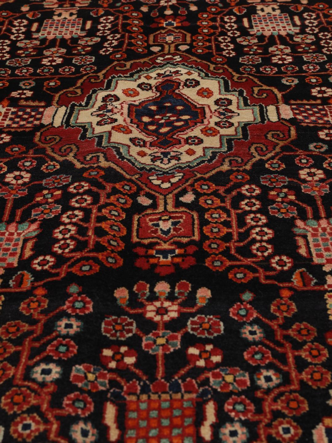 Handgeknoopt Hamadan tapijt uit het Midden-Oosten met een donkerrood en zwart floraal medaillonontwerp