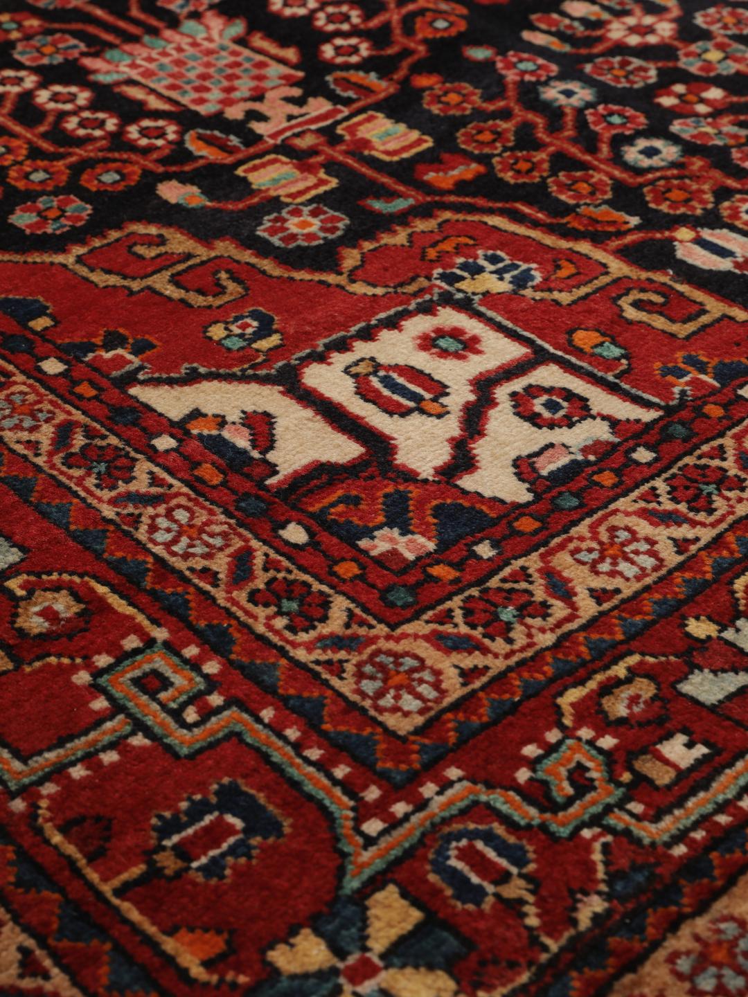 Handgeknoopt Hamadan tapijt uit het Midden-Oosten met een donkerrood en zwart floraal medaillonontwerp