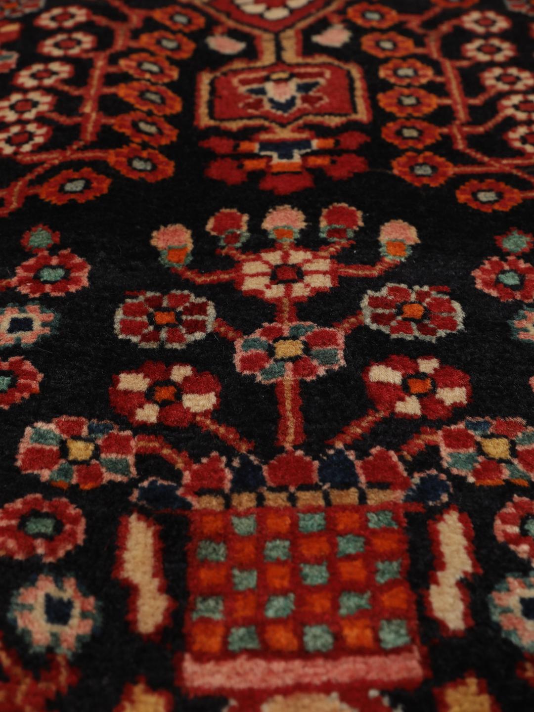 Handgeknoopt Hamadan tapijt uit het Midden-Oosten met een donkerrood en zwart floraal medaillonontwerp