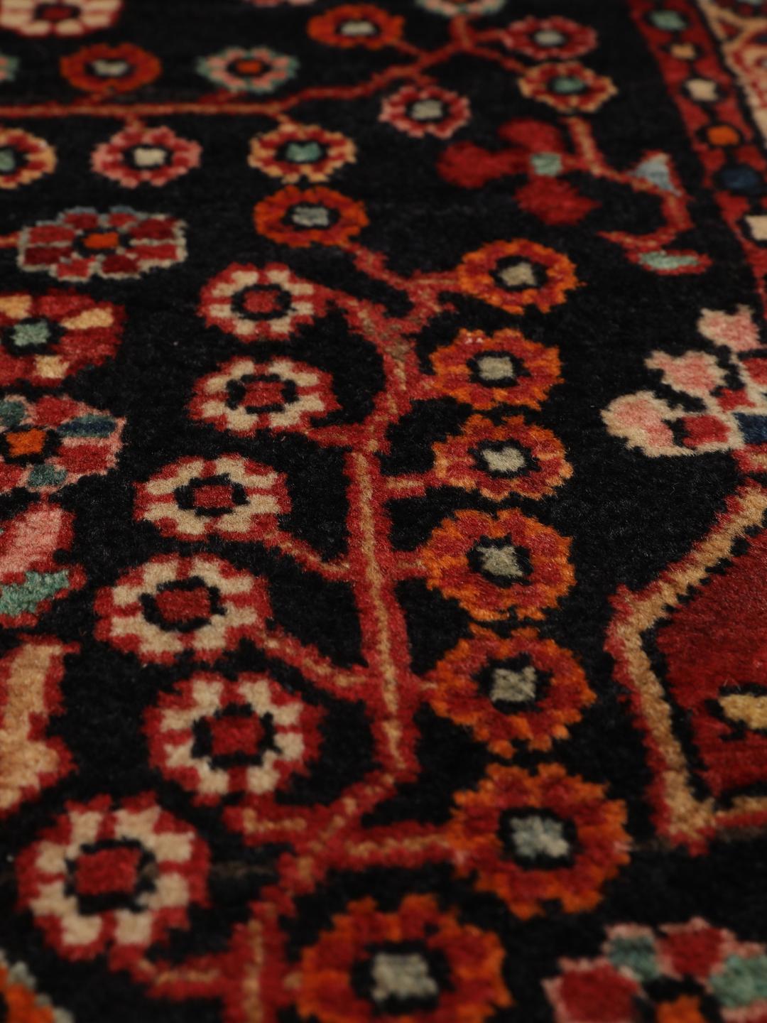 Handgeknoopt Hamadan tapijt uit het Midden-Oosten met een donkerrood en zwart floraal medaillonontwerp