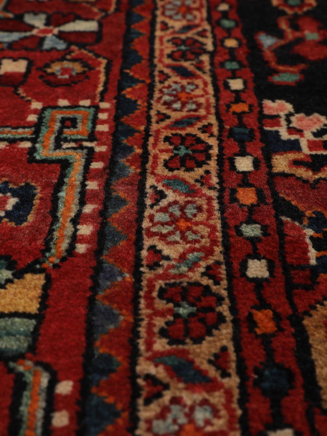 Handgeknoopt Hamadan tapijt uit het Midden-Oosten met een donkerrood en zwart floraal medaillonontwerp