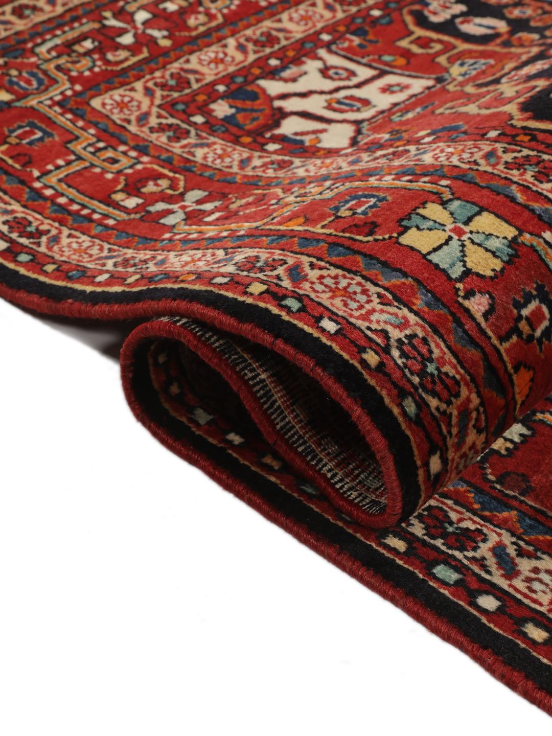 Handgeknoopt Hamadan tapijt uit het Midden-Oosten met een donkerrood en zwart floraal medaillonontwerp