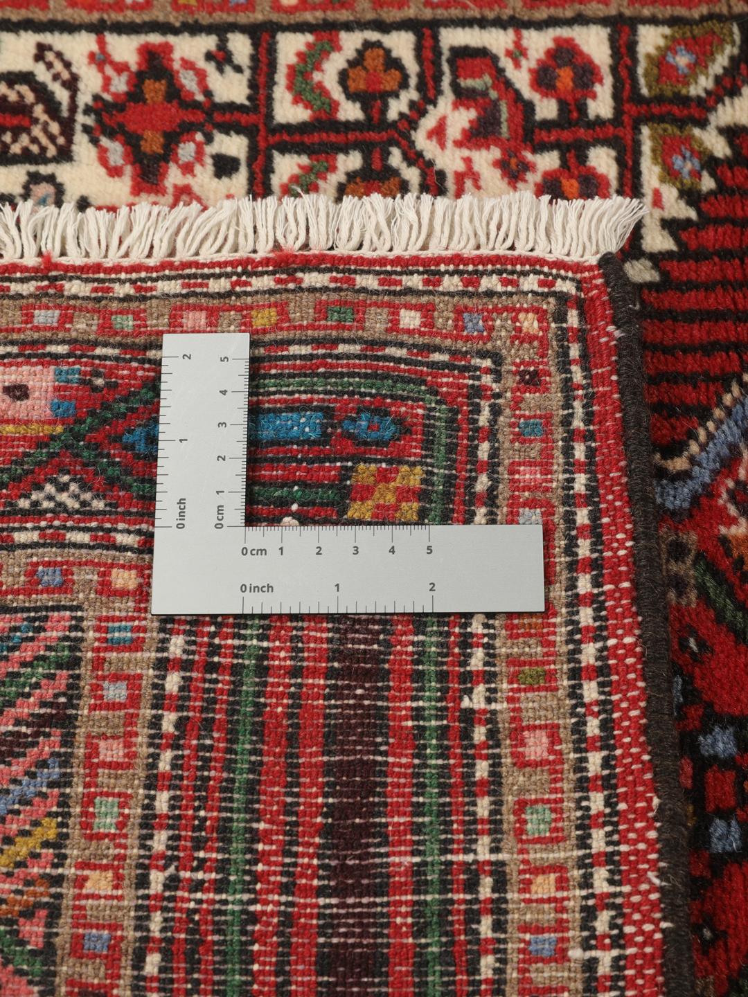 A hand-knotted Hamadan runner with traditional geometric patterns in red and cream.