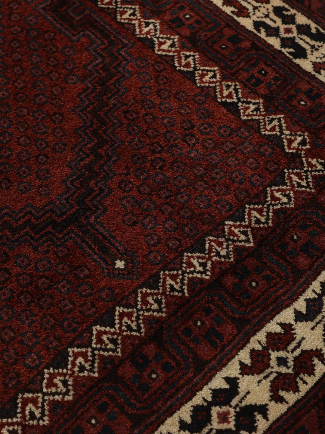A hand-knotted Afshar rug from the Middle East in deep red featuring geometric medallions.