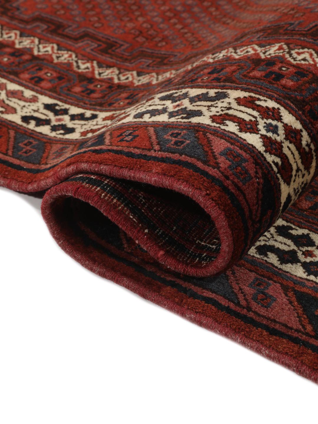 A hand-knotted Afshar rug from the Middle East in deep red featuring geometric medallions.