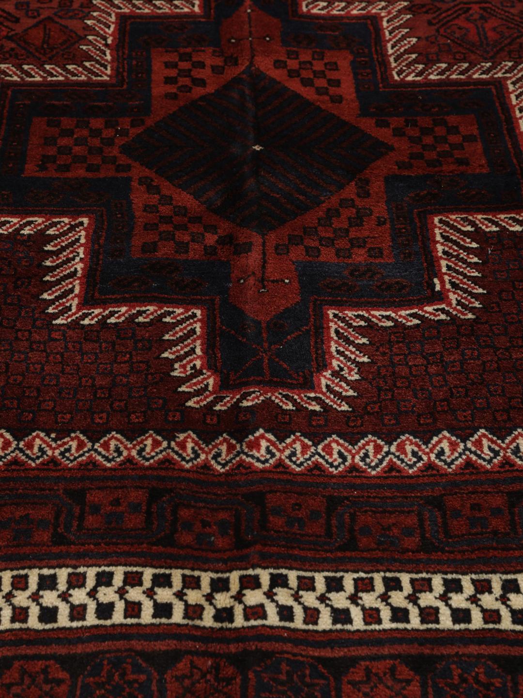 Hand knotted rug from the Middle East in dark red tones