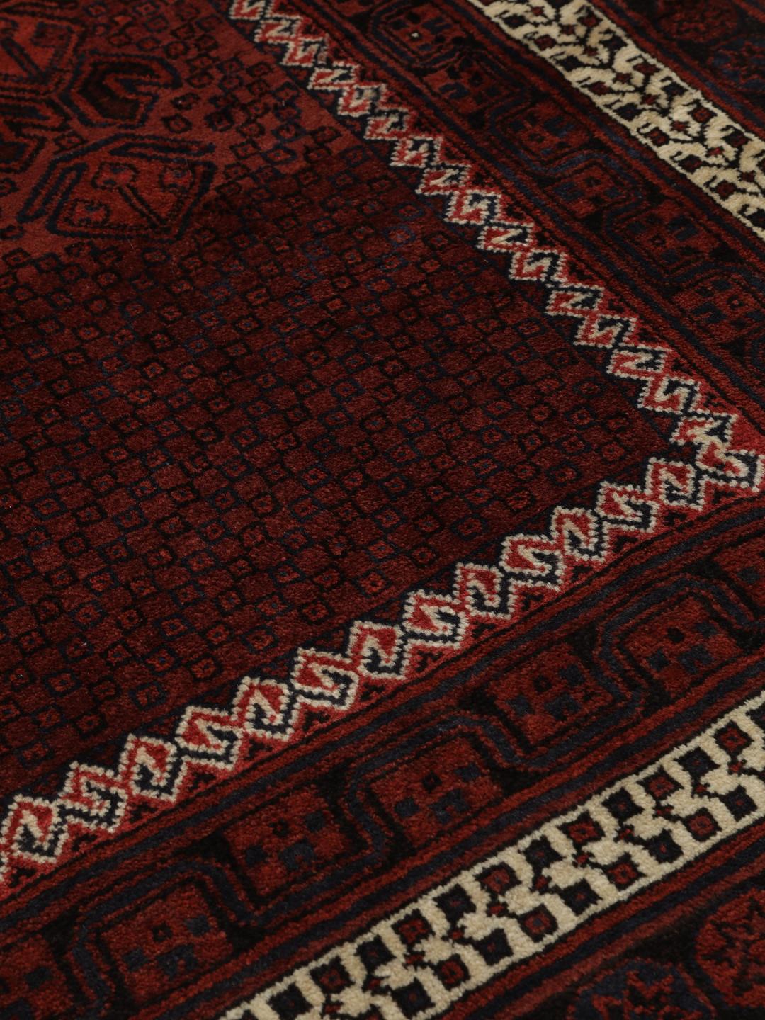 Hand knotted rug from the Middle East in dark red tones