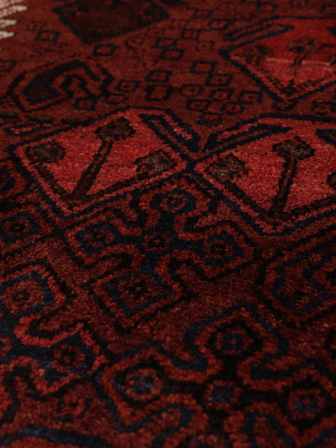 Hand knotted rug from the Middle East in dark red tones