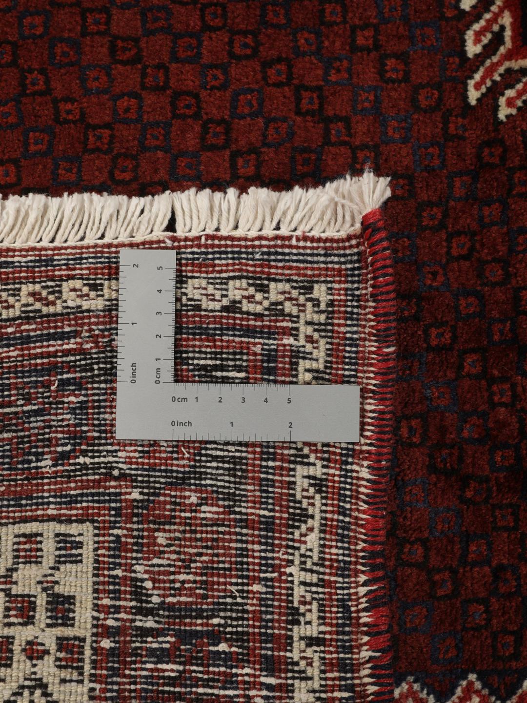 Hand knotted rug from the Middle East in dark red tones