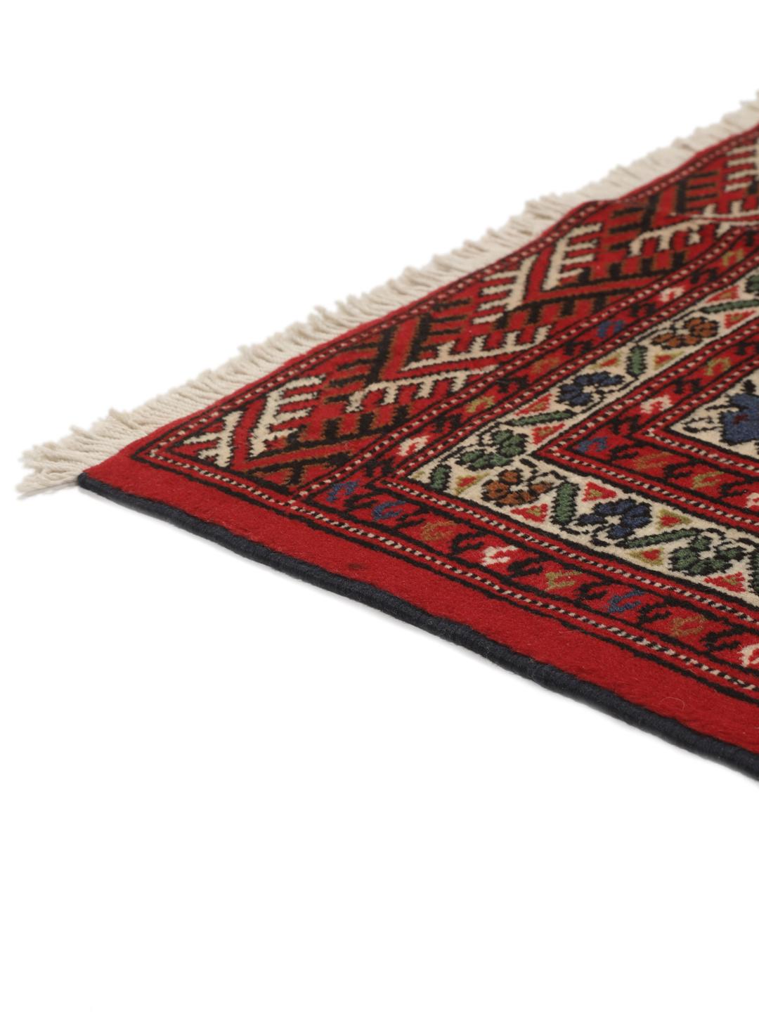 A hand-knotted Turkaman rug from the Middle East with a deep red field and traditional geometric motifs.