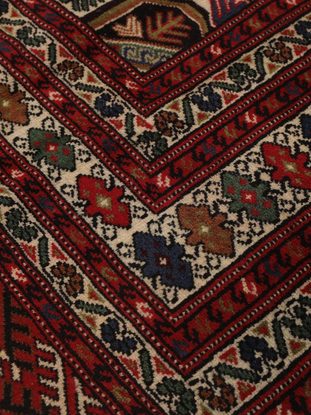 A hand-knotted Turkaman rug from the Middle East with a deep red field and traditional geometric motifs.