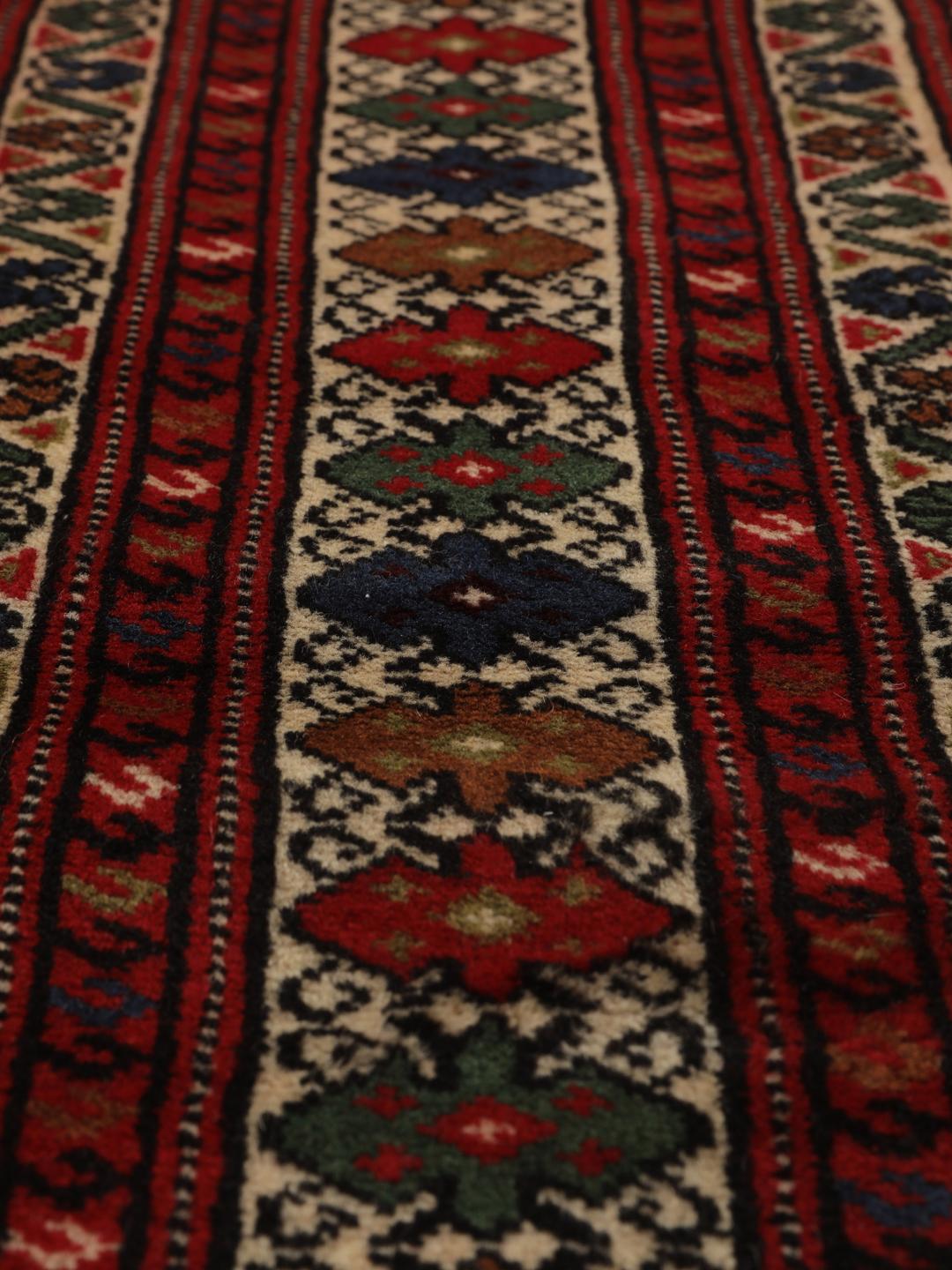 A hand-knotted Turkaman rug from the Middle East with a deep red field and traditional geometric motifs.