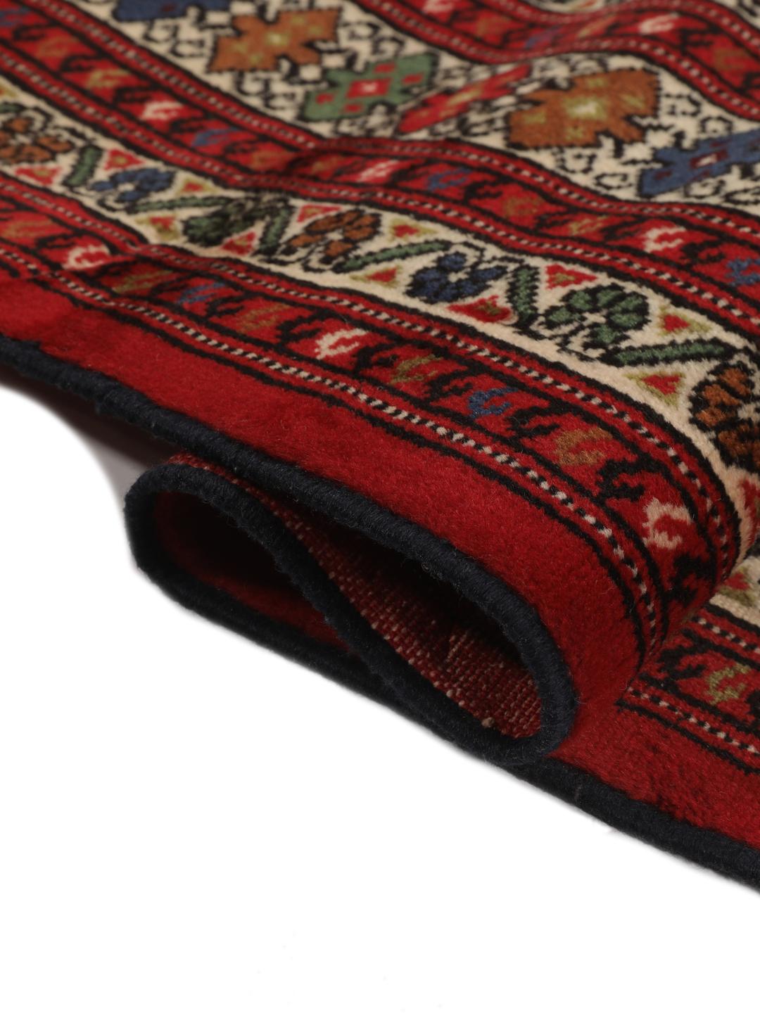 A hand-knotted Turkaman rug from the Middle East with a deep red field and traditional geometric motifs.