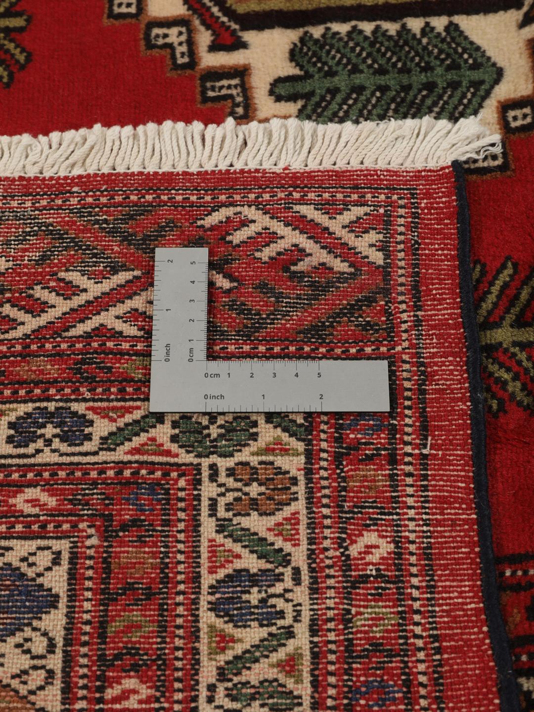 A hand-knotted Turkaman rug from the Middle East with a deep red field and traditional geometric motifs.