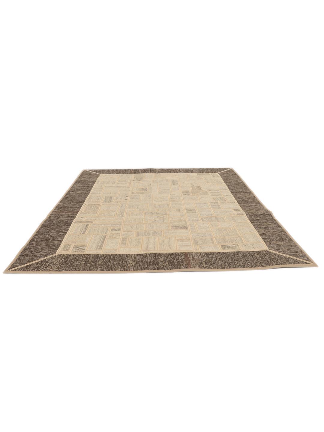 Un tapis patchwork rectangulaire avec des motifs géométriques en beige et marron, tissé à la main au Moyen-Orient.