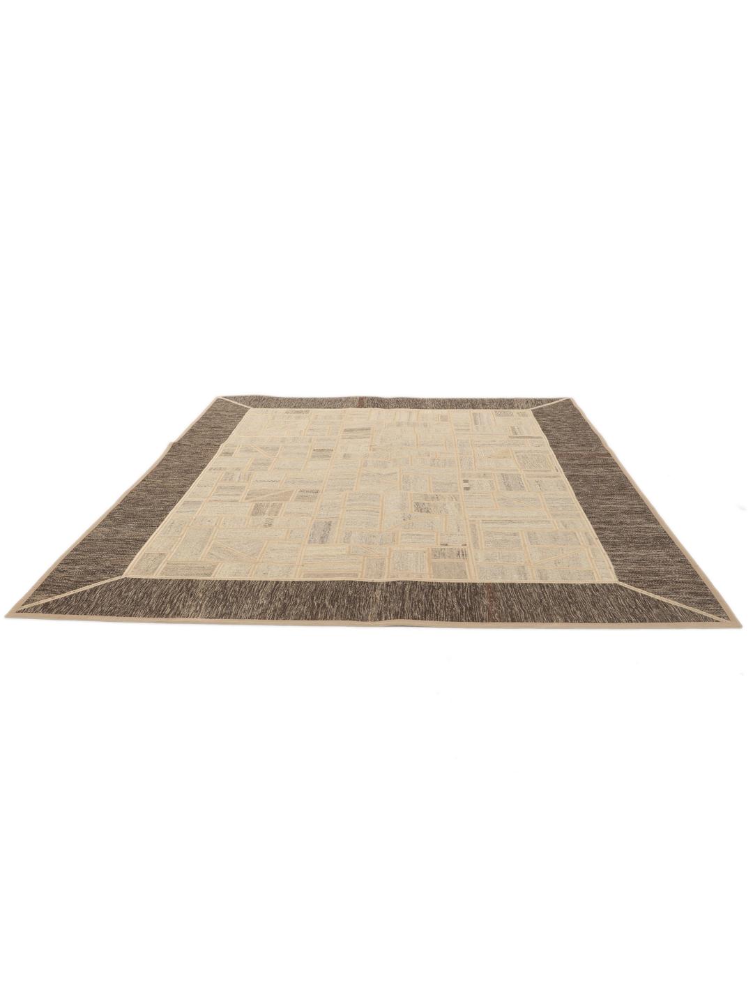 Un tapis patchwork rectangulaire avec des motifs géométriques en beige et marron, tissé à la main au Moyen-Orient.