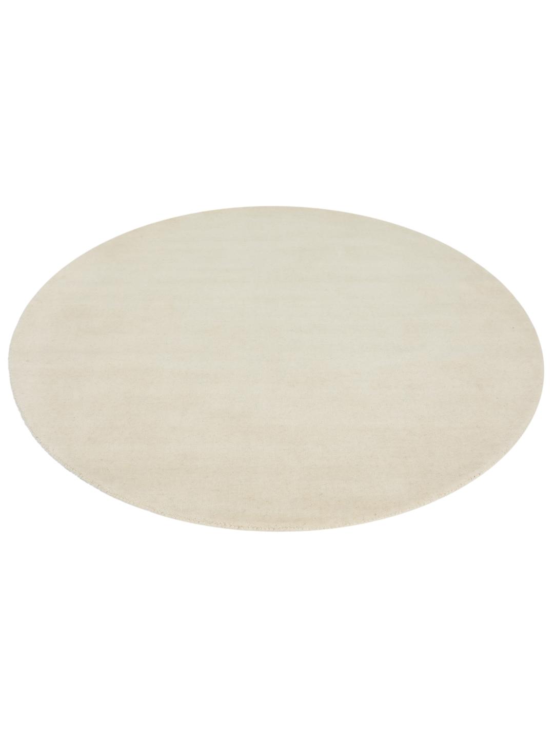 Een rond wit handgeweven vloerkleed gemaakt van wol